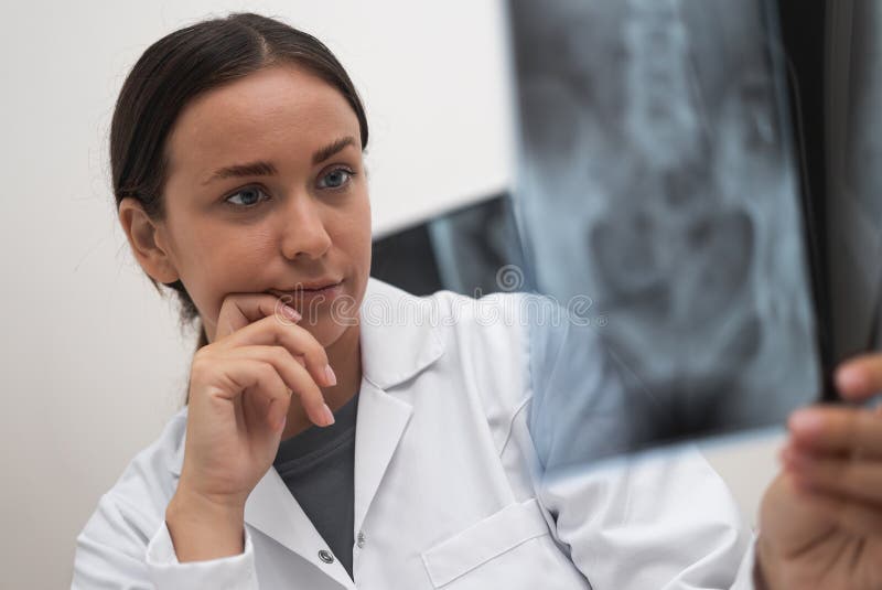 close up of doctor worried looks at radiological X-ray film to evaluate the patient&#x27;s condition royalty free stock photos
