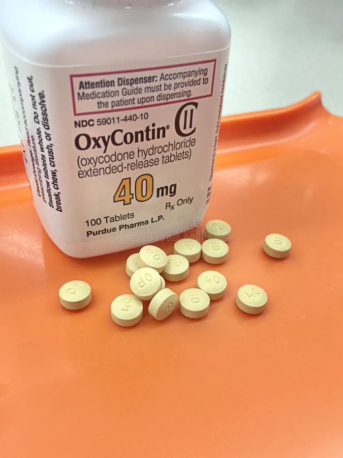 Oxycodone bottle on pharmacy tray with tablets poured out stock photo