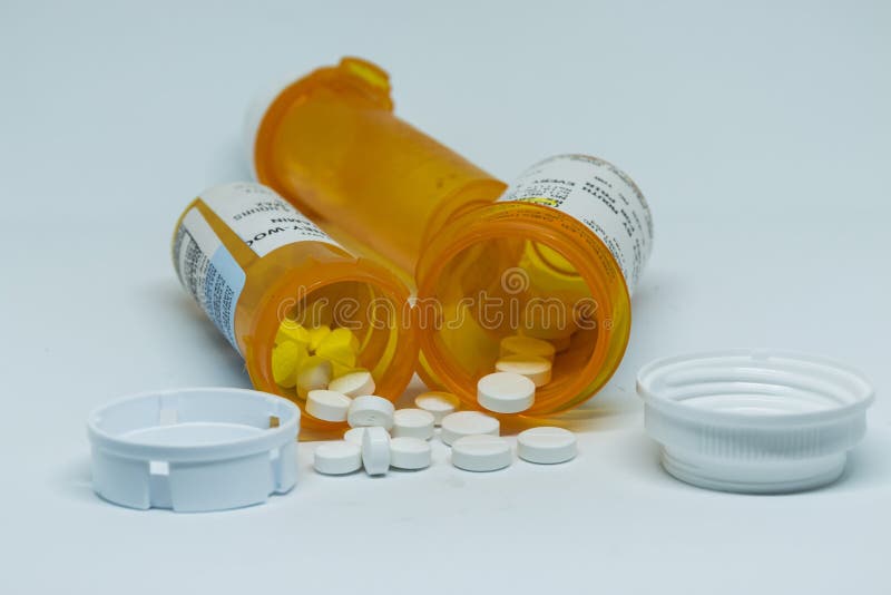 Oxycodone pills spilled out of perscription containers stock images
