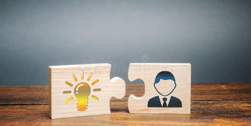 Wooden puzzles with the image of a light bulb of idea and employee. Generation of innovative business ideas. Creative process. stock images