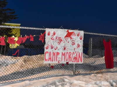 Small red dresses with the names of Murdered and Missing Indigenous Women, Girls and Two-Spirit people hang near a sign for Camp Morgan on the fence surrounding the Brady Road landfill outside Winnipeg, Manitoba, on March 3, 2023.