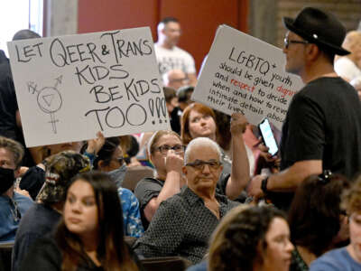 People hold up signs in support of gay and transgender student rights during the Chino Valley Unified School District board meeting at Don Lugo High School in Chino, California, on July 20, 2023.