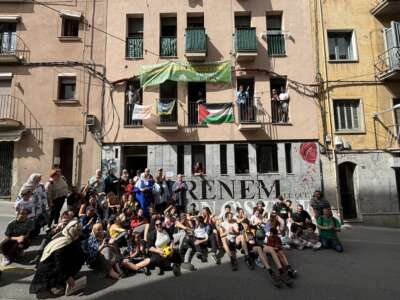 Members of PAHC sit outside of the reclaimed building where Pablo and Nadia live in Manresa, Catalonia, on May 5, 2024, to celebrate the squat’s one-year anniversary.