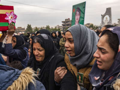 People mourn during the funeral procession of a member of the Women's Protection Units (YPJ), who was killed during a Turkish drone strike in the countryside of Kobani a day earlier, in Syria's northeastern city of Qamishli, on December 22, 2024.