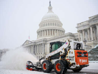 A man uses a 'Bobcat' compact track loader to plow snow before Senators and Representatives attend a joint session of Congress to certify the Electoral College votes of the 2024 presidential election in the House chamber on January 6, 2025, at the U.S. Capitol in Washington, D.C.