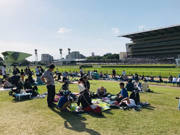 競馬の魅力 芝生でピクニックしながら競馬を楽しむ