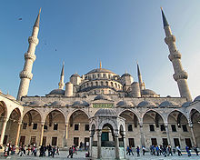 A building with six minarets, one central dome, four semi-domes and numerous small domes.