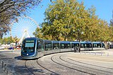 Photographie d'un tramway passant devant le Grand Théâtre et ses colonnes de pierre.