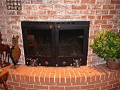 Custom-fitted fireplace insert with large glass doors, and a large heat exchanger for efficiency