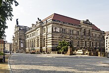 Barevná fotografie s pohledem na monumentální budovu ve stylu historismu s výraznou bosáží