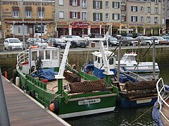 deux petits bateaux de pêche colorés dotés d'un filet enroulé à l'arrière