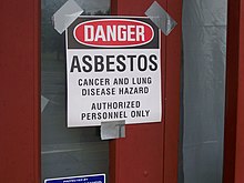 A sign reads "Danger, asbestos, cancer and lung disease hazard, authorized personnel only"