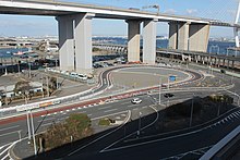 2017年に新設された名古屋市営金城ふ頭駐車場への連絡路。画像左 :インター料金所を出て現れるループ。画像右：ループ通過後、インターのランプウェイの下をくぐり抜けて金城ふ頭駐車場に直通。