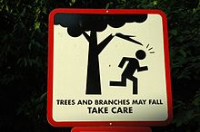 A sign with a figure running under a branch