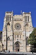 La cathédrale qui domine la large place piétonne. Un tramway passe devant elle.