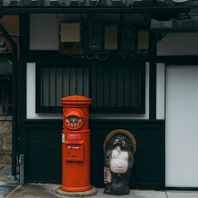 日本の軒先文化のたぬきの置物とポストの写真