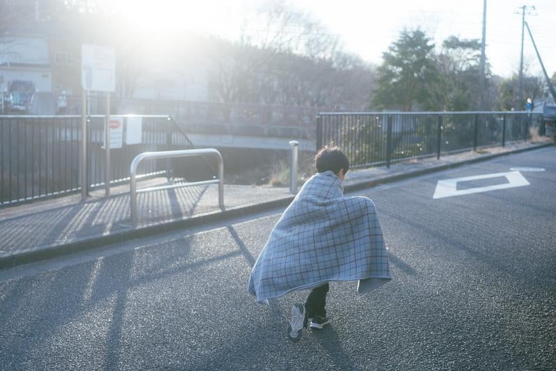 散歩中のブランケットを着る子供の写真