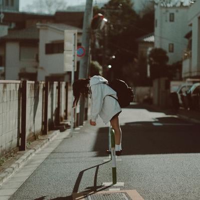 青春の疲れとともに歩む女子高生の通学路の写真