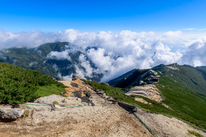 雲に包まれる中央アルプスと駒峰ヒュッテの写真