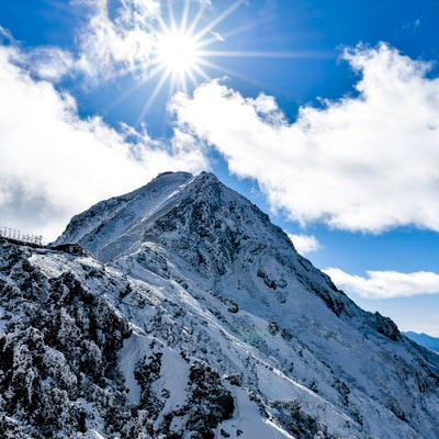 太陽をその頭に抱く雪の赤岳（あかだけ）の写真