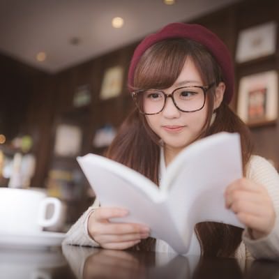 カフェで調べ物をするメガネをかけた美少女の写真