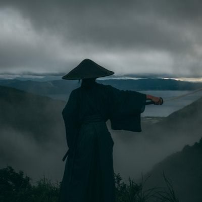 迫りくる灰色の雲と日本刀を翳す侍の写真