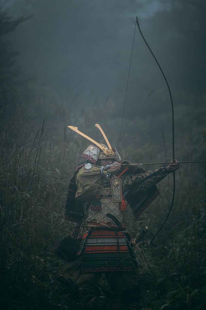 藪の中で大弓を引く武士の写真