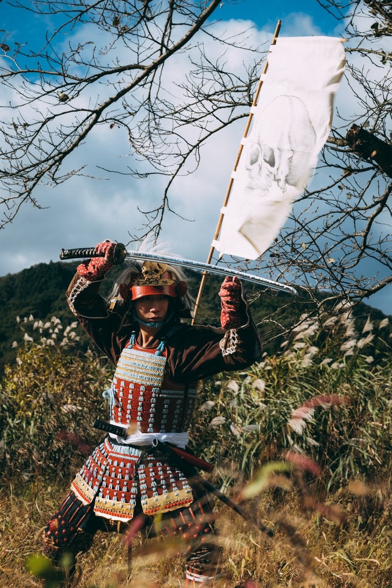 刀を頭上に構える甲冑を纏った武士の写真