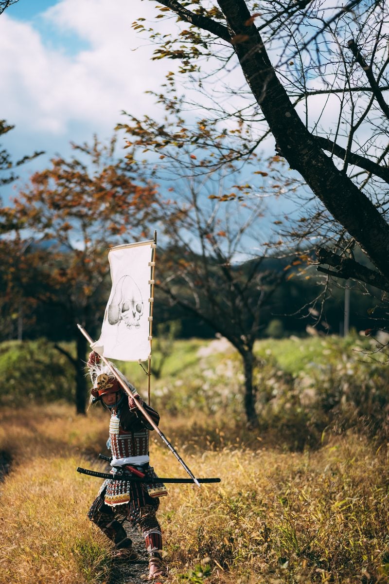 風に揺れる長槍と武器を構える侍の写真