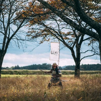 草むらで長槍を構える甲冑を纏う侍の写真