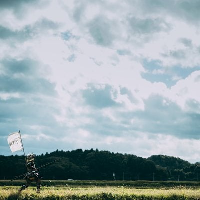 指物を風に揺らし逃走する侍の写真