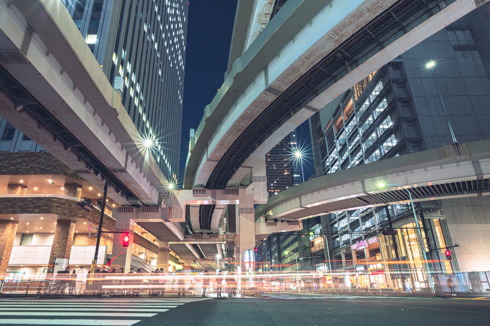 「池袋のビル群と往来する車の光跡」の写真