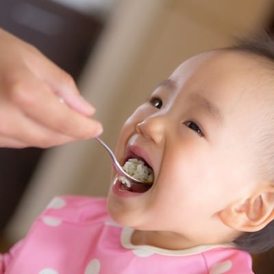 大きなお口でご飯をあーんする赤ちゃんの写真