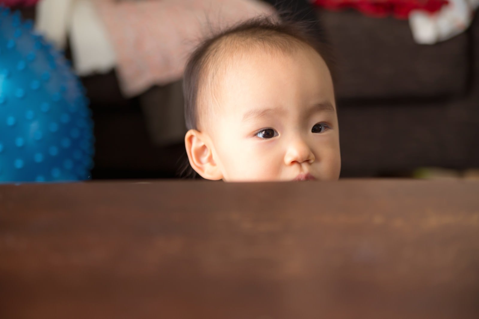 「テーブルからひょこと顔を出したあかちゃん」の写真［モデル：あんじゅ］