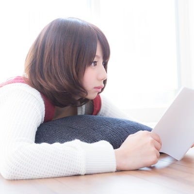 マンガを読みながらテレビのニュースが気になる週末美女の写真