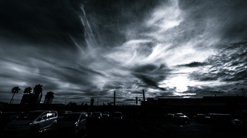 駐車場からの雲行き（モノクロ）の写真