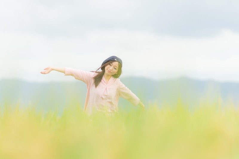 金色の稲穂ともんぺ女子の写真