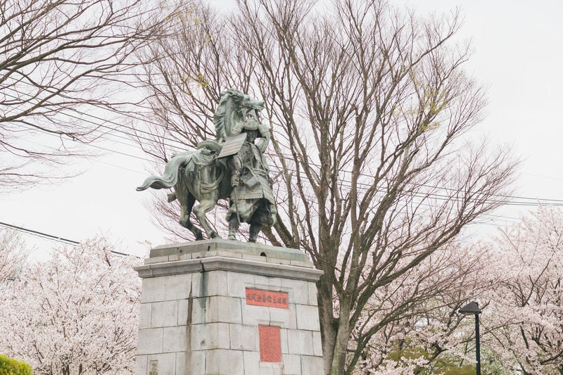 大刀洗公園の菊池武光像と桜の写真