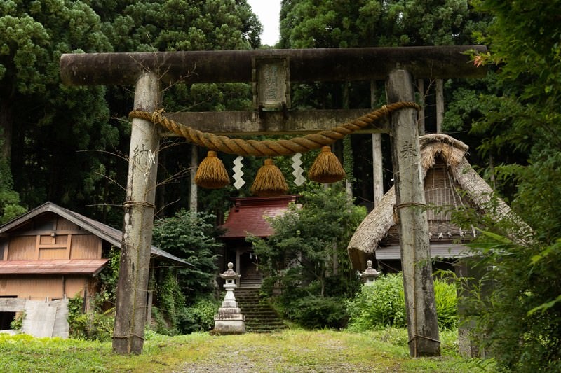 年季が入る鳥居と菅沼集落の写真