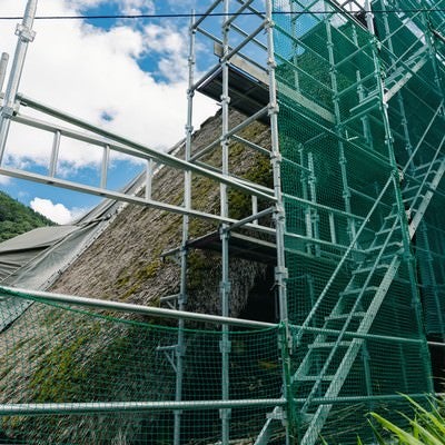 村上家の茅葺屋根にかかる足場（富山県南砺市）の写真