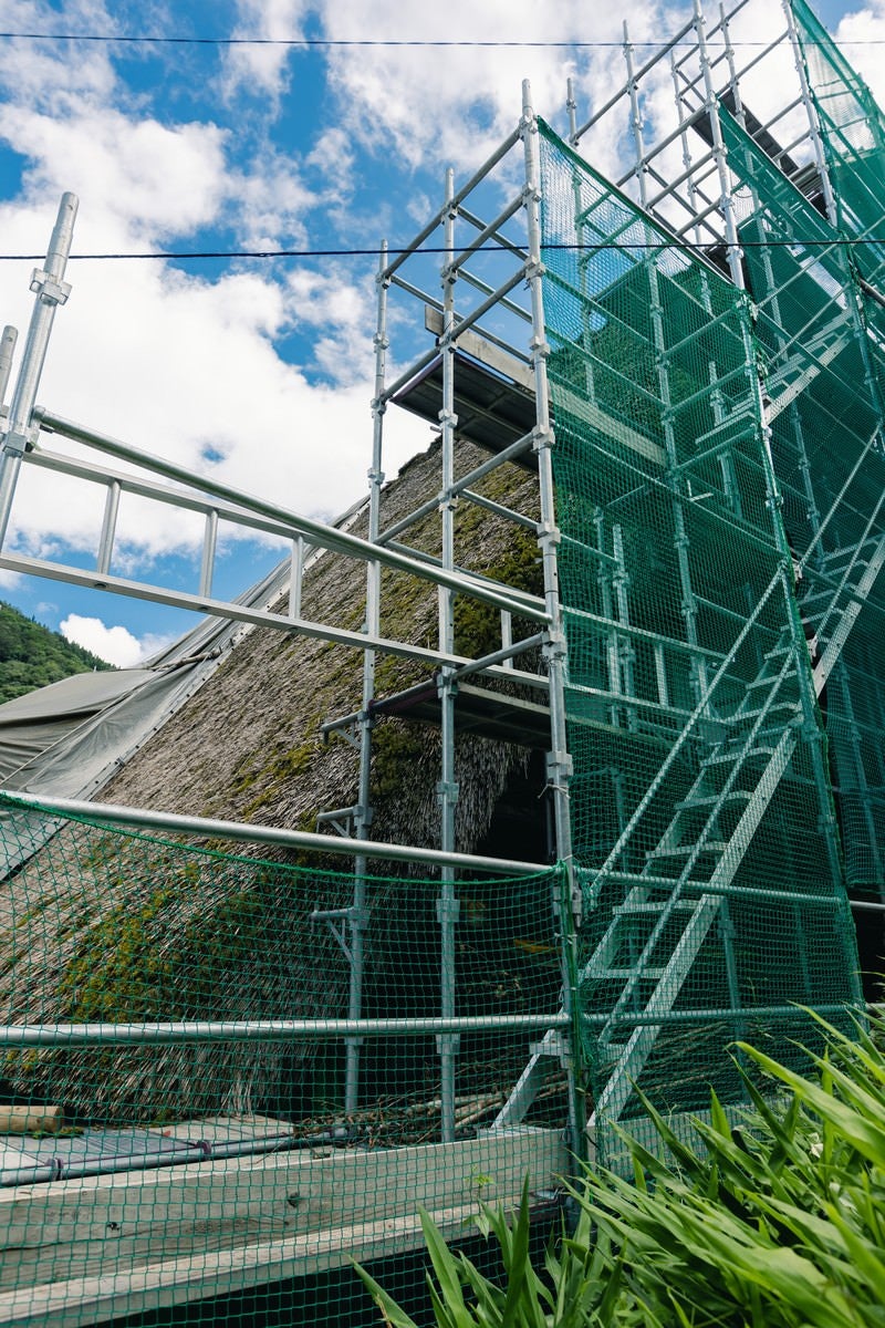 村上家の茅葺屋根にかかる足場（富山県南砺市）の写真