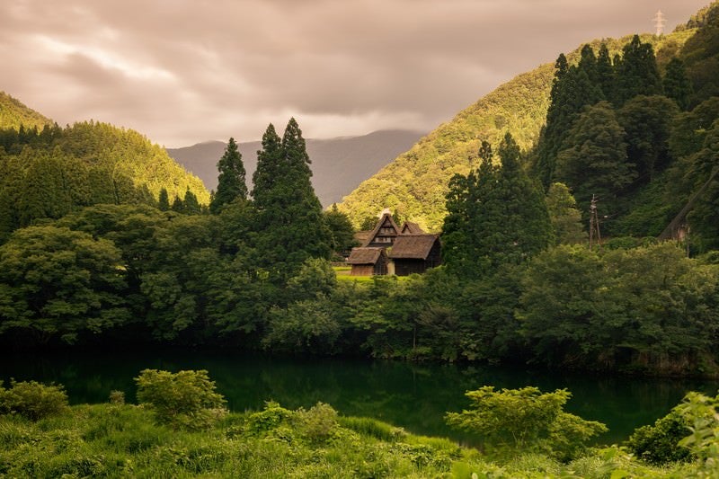 川向こうに見える合掌造りの集落の写真