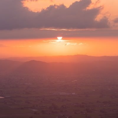 沈みゆく夕日と黄昏時の散居村（富山県南砺市）の写真