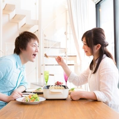 夫を餃子で餌付けする妻と単純な夫の写真