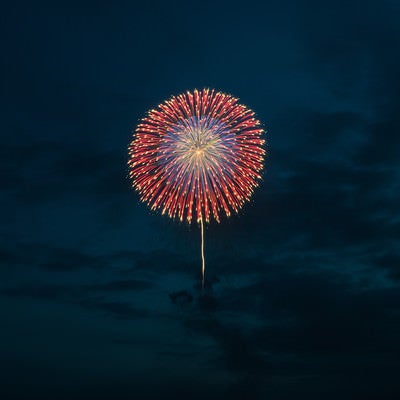 日が落ちてきた夜空に上がる花火の写真