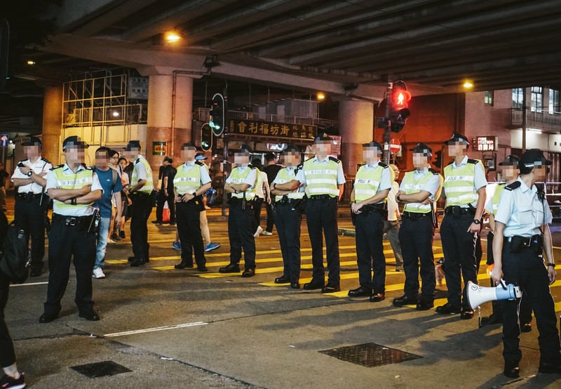 香港デモで道を塞ぐ警察官の写真