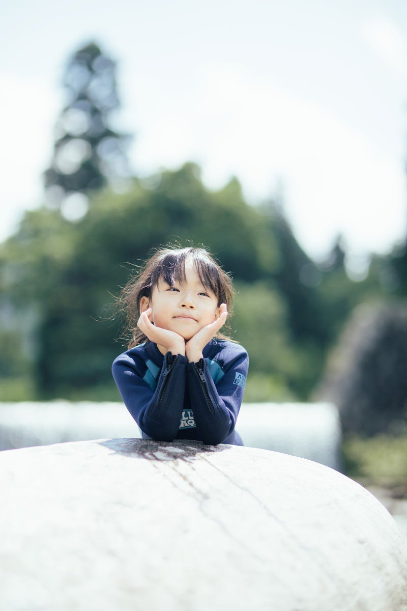 川遊びで冷えた体を温める女の子の写真