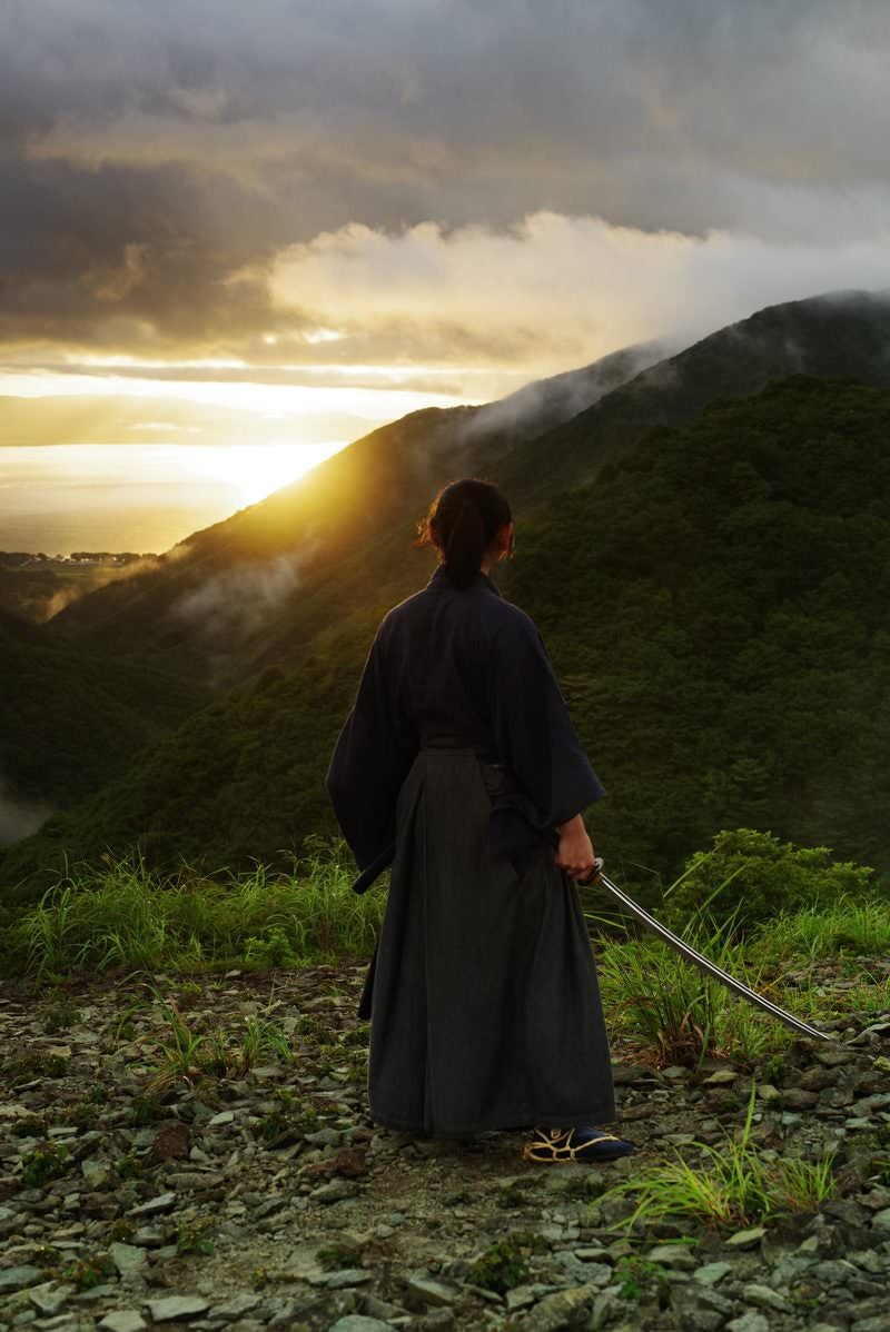 神々しい夕日を眺める侍（御霊櫃峠）の写真