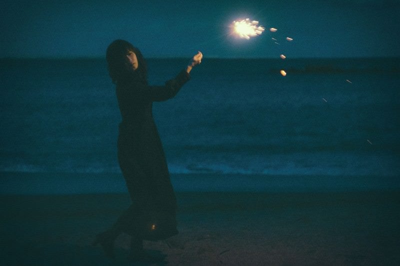 悲しい表情で手持ち花火の写真