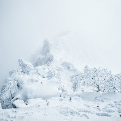 ガスに包まれた稜線と雪景色の写真